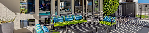 a patio with blue and green chairs and a table